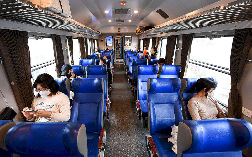 Cushioned train seats with limited recline, offering basic comfort for short to medium-distance travel